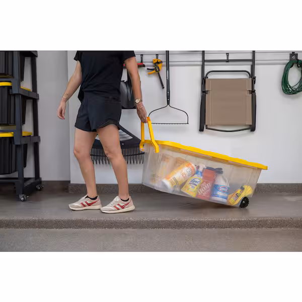 40 Gal. Tough Storage Tote with Wheels and Handle in Clear and Yellow in use